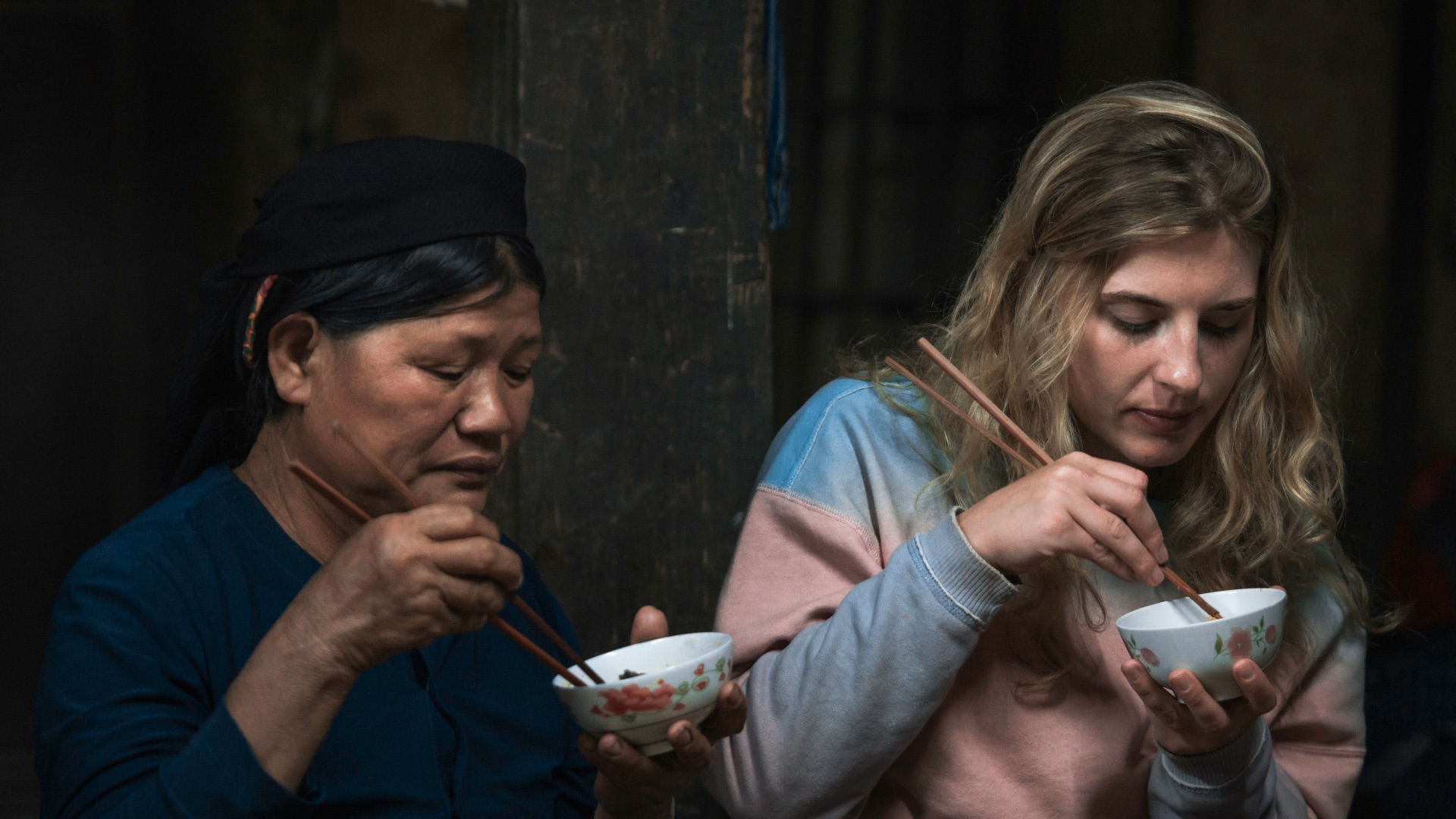 two women using chopsticks for eating