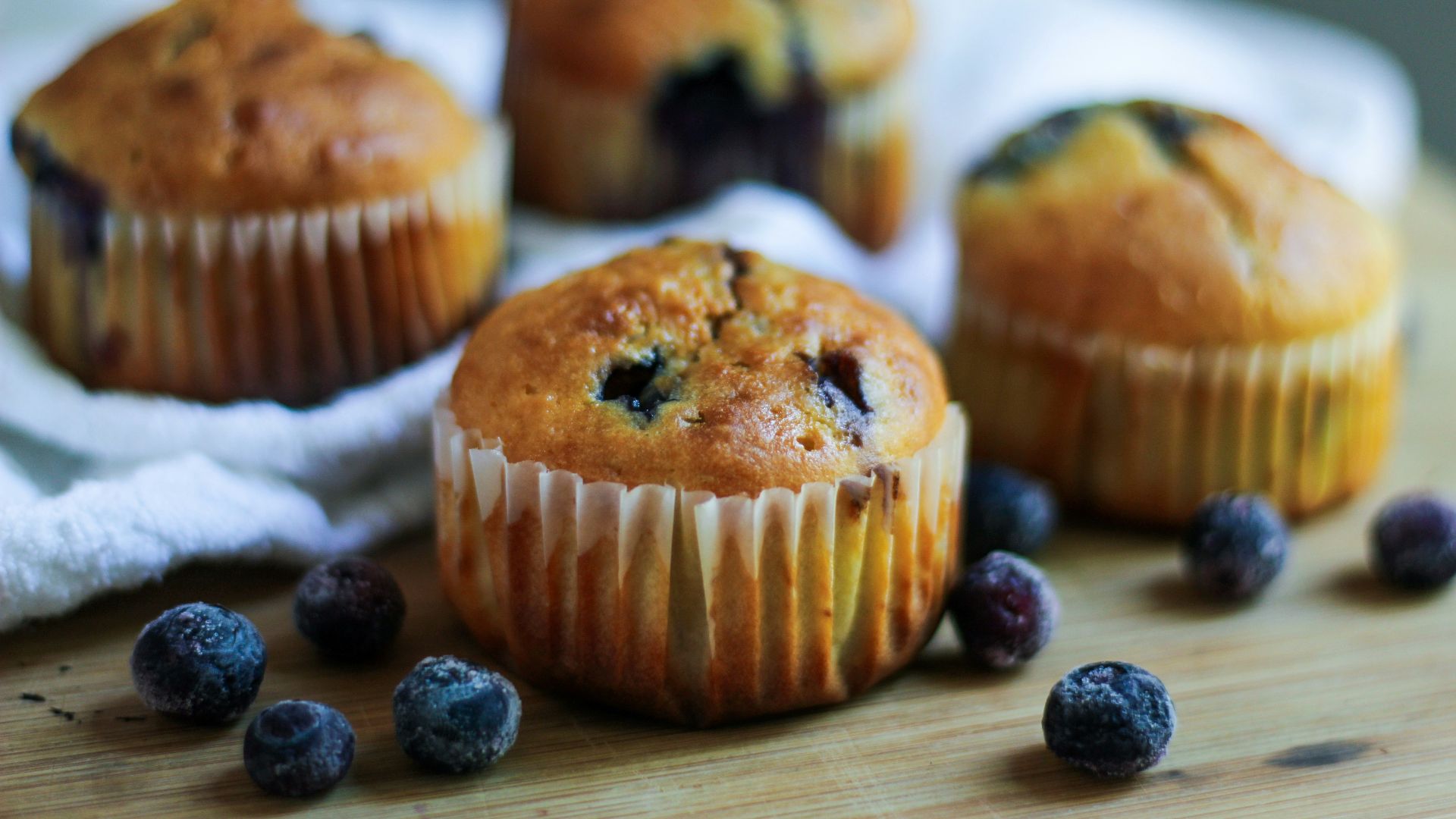 a bunch of blueberry muffins sitting on top of a wooden table