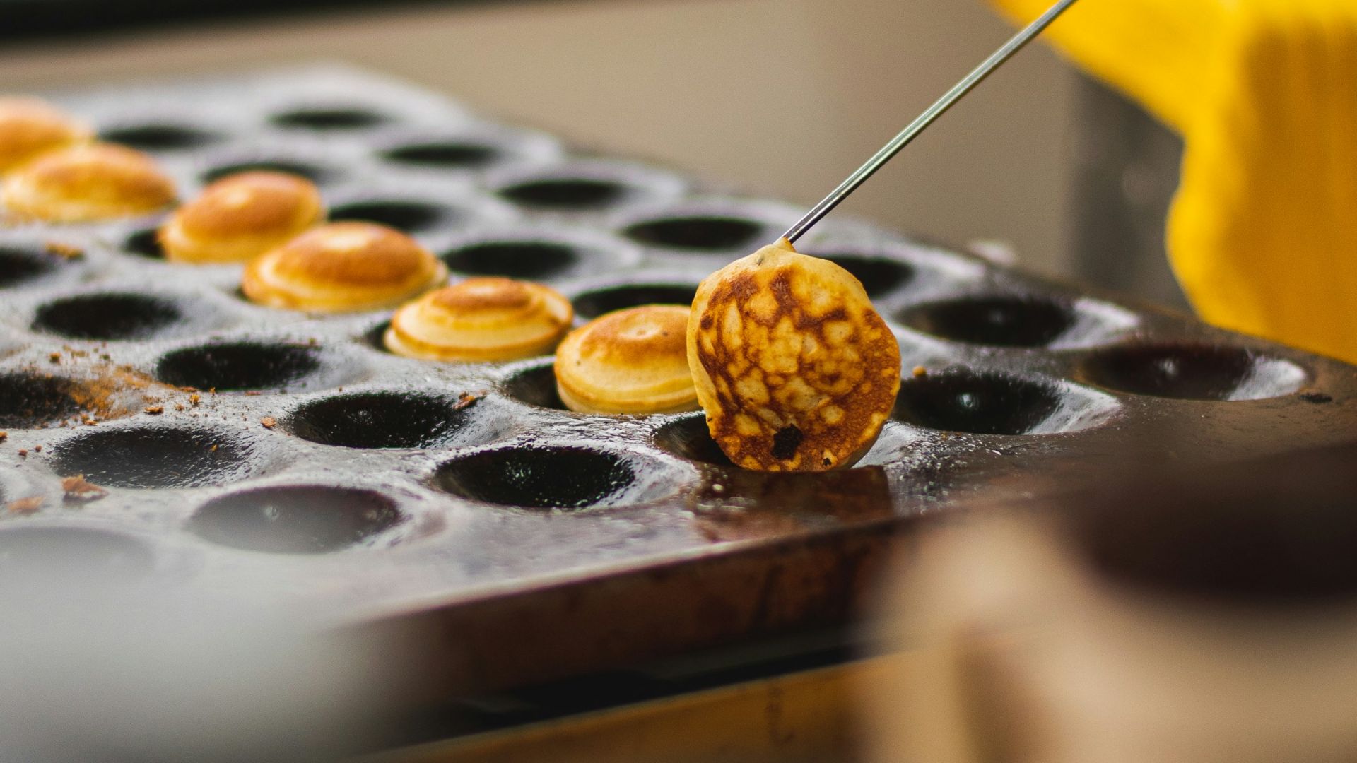 a person using a pair of tongs to cut a donut