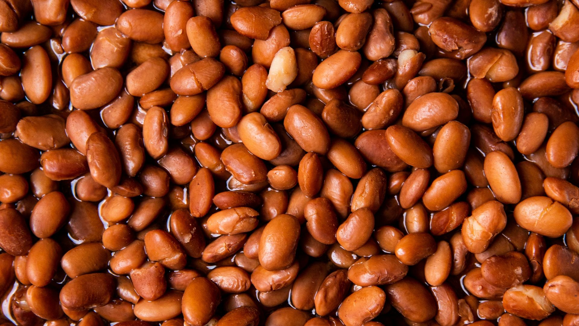 brown coffee beans on brown wooden surface