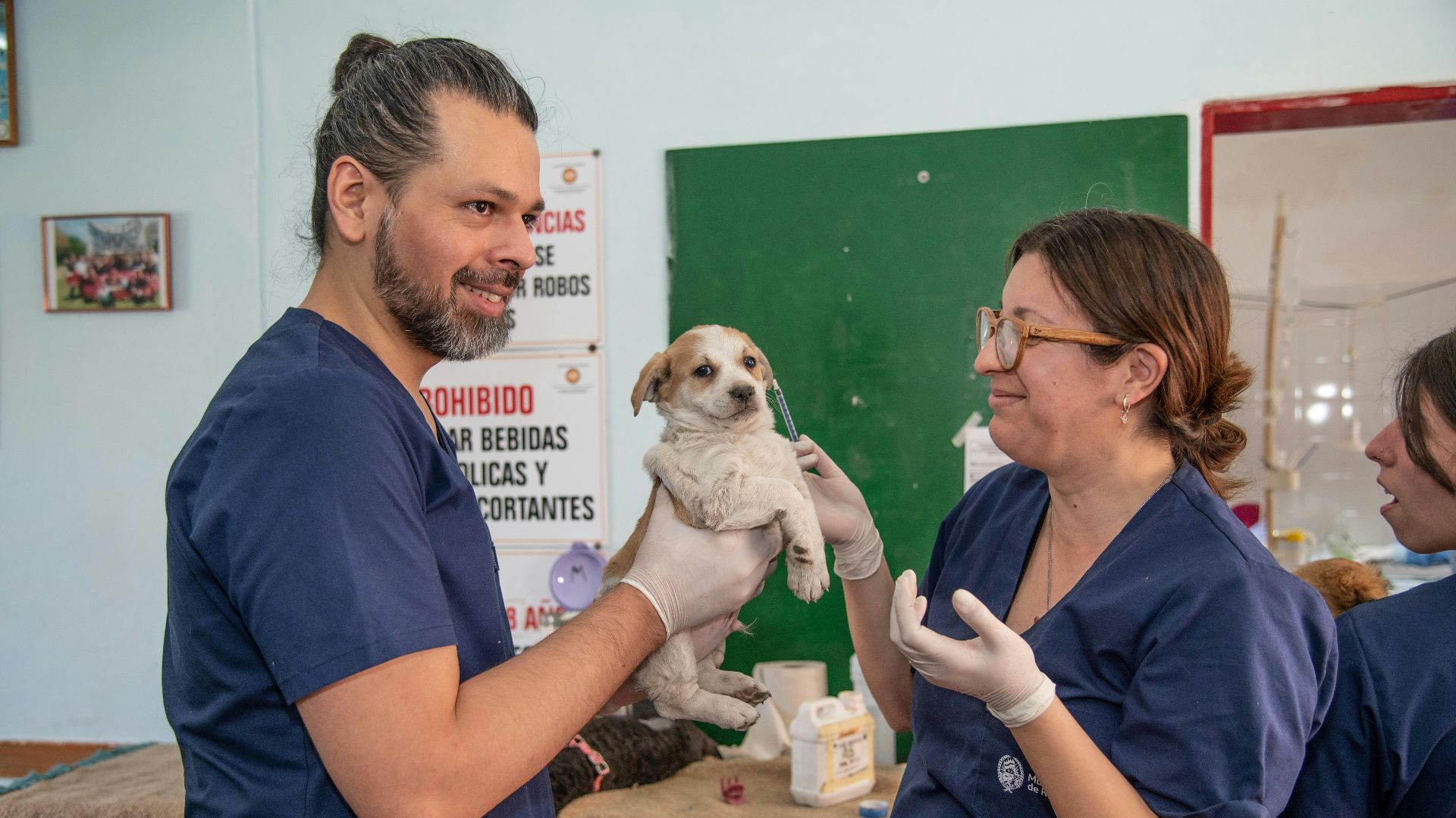 a man holding a small dog in a room