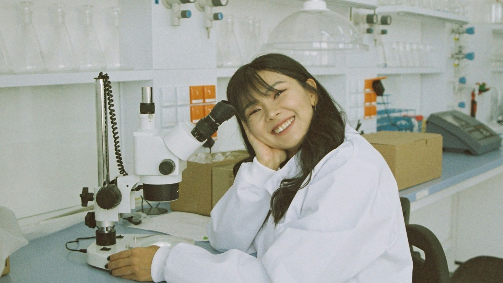 woman in white laboratory gown holding black microphone