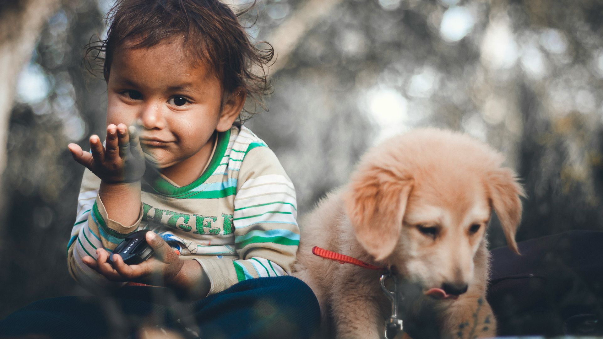 boy in green white and red striped shirt drinking from bottle