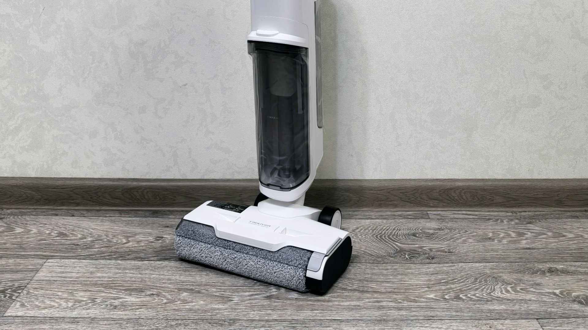 A floor sweeper sitting on top of a hard wood floor