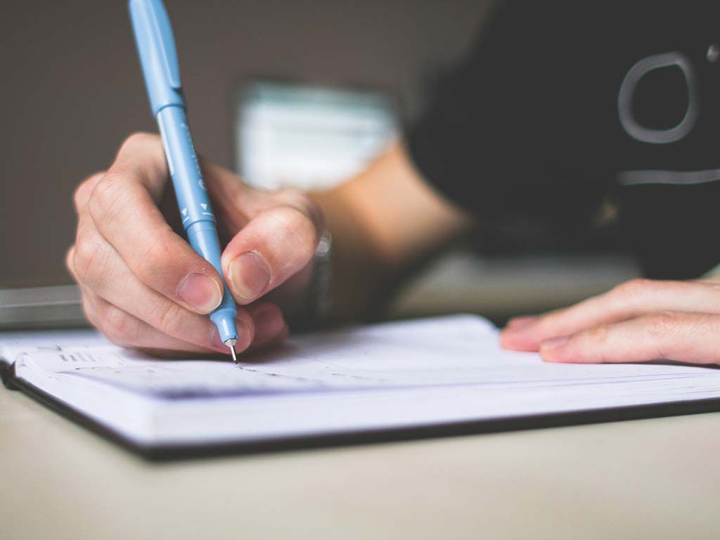 resizeperson-holding-blue-ballpoint-pen-writing-in-notebook-210661.jpg.optimal.jpg