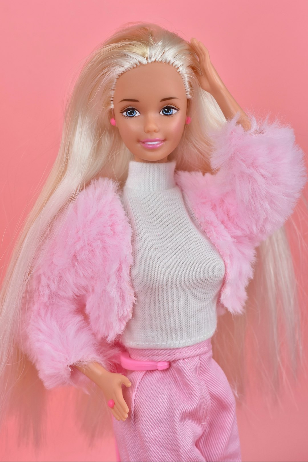 A barbie doll with blonde hair and pink pants
