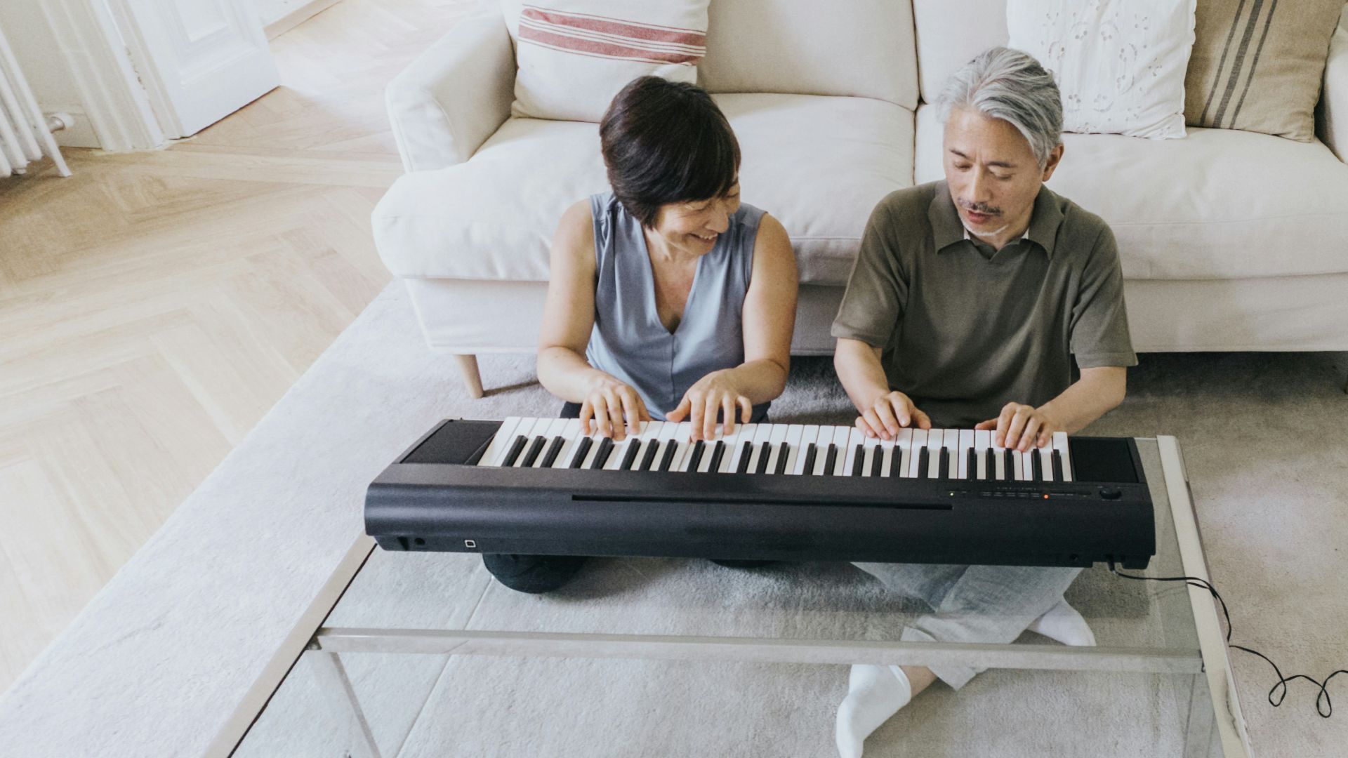 a man and a woman playing a piano on a couch