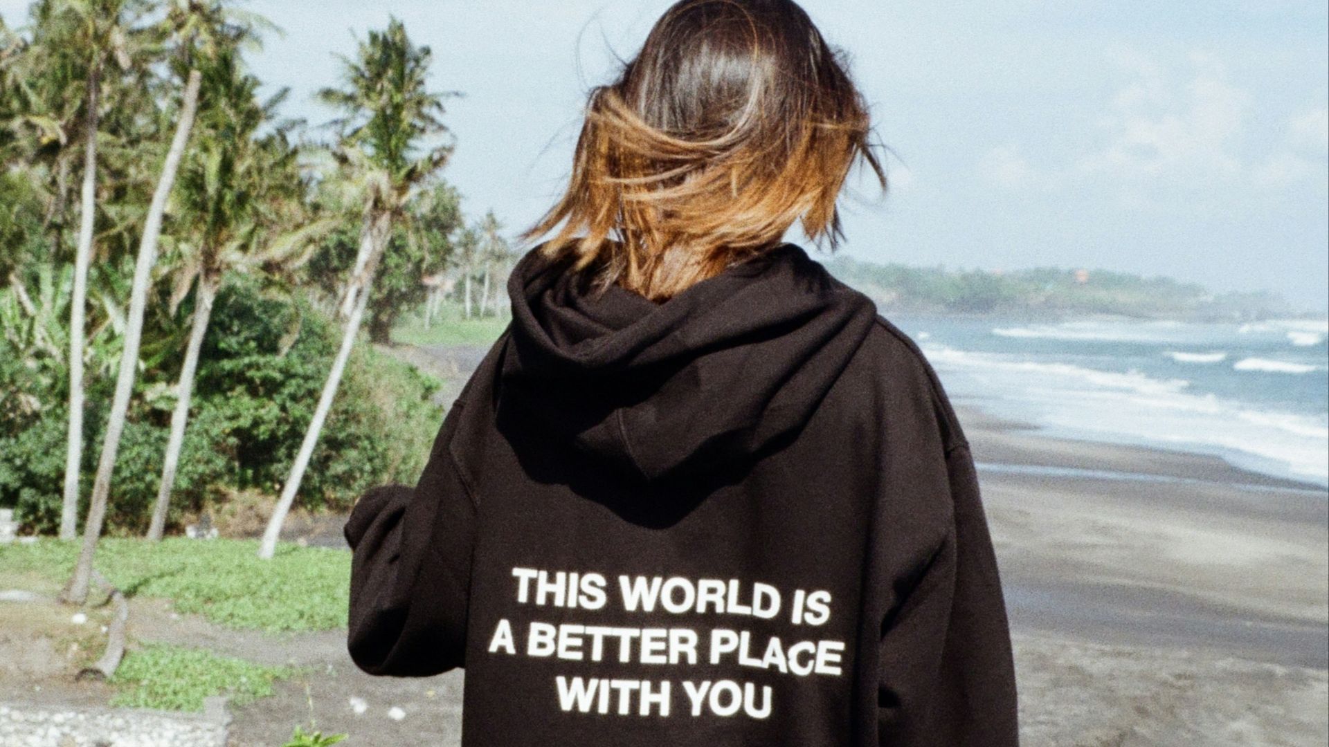 a woman in a black hoodie that says, this world is a better place