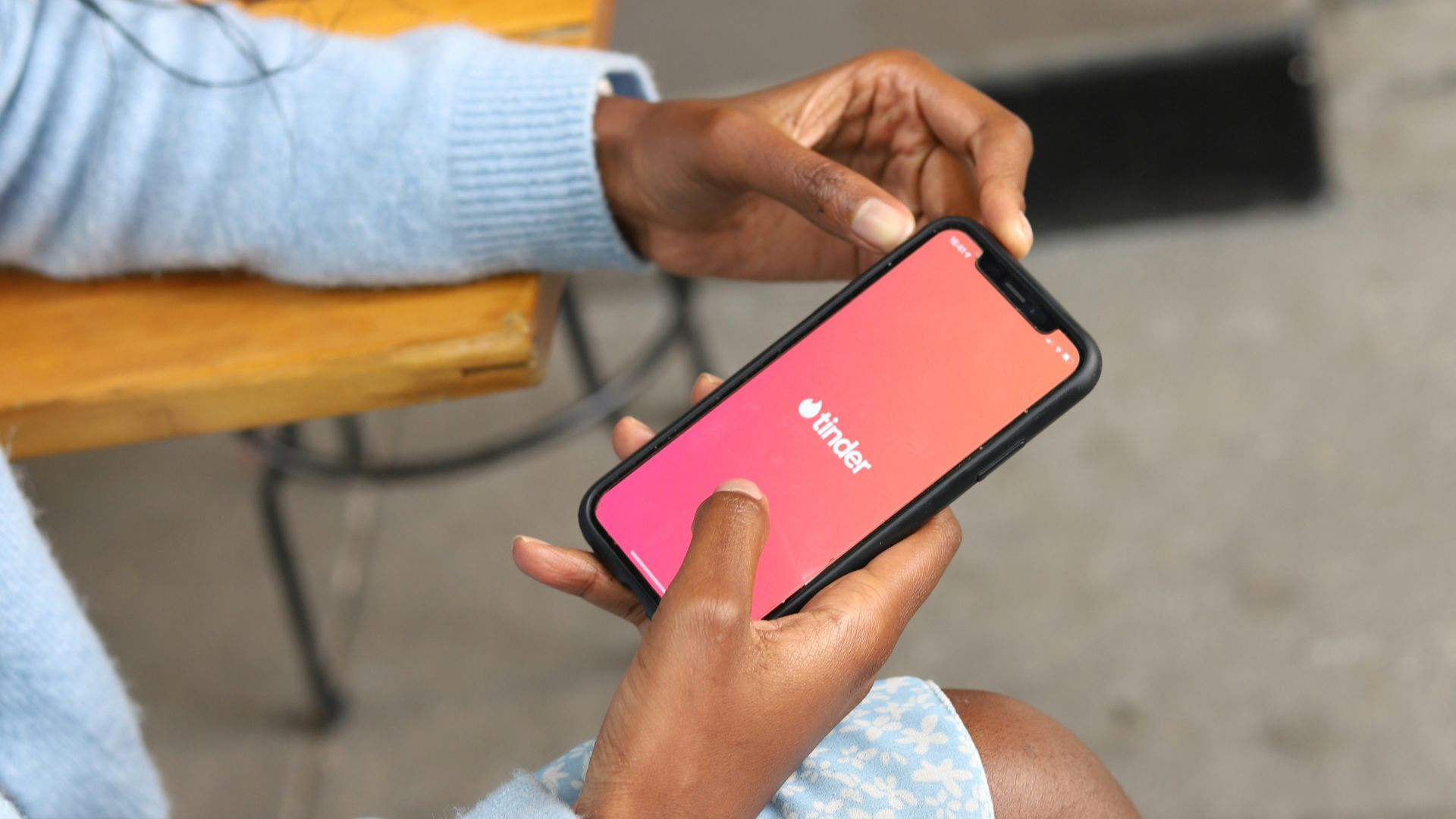 a woman sitting on a bench holding a cell phone