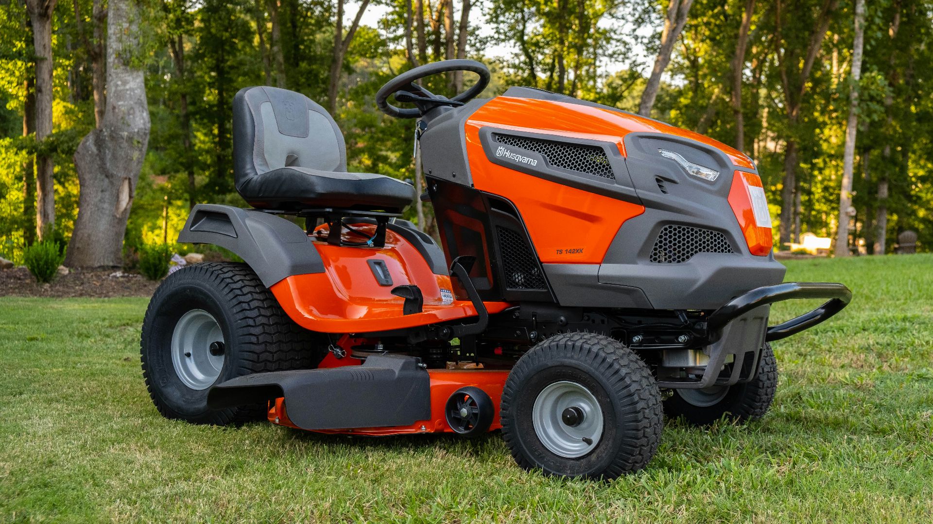 orange and black ride on lawn mower on green grass field