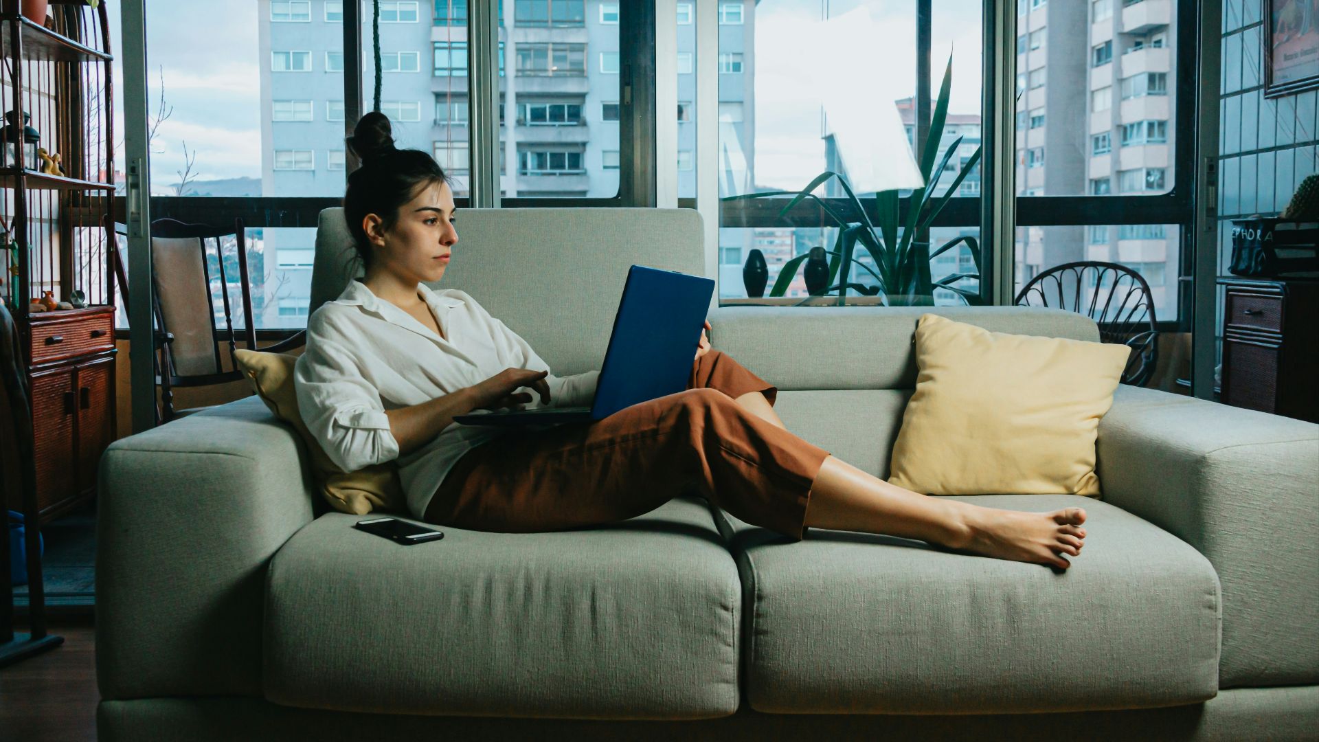 woman in white long sleeve shirt sitting on white couch
