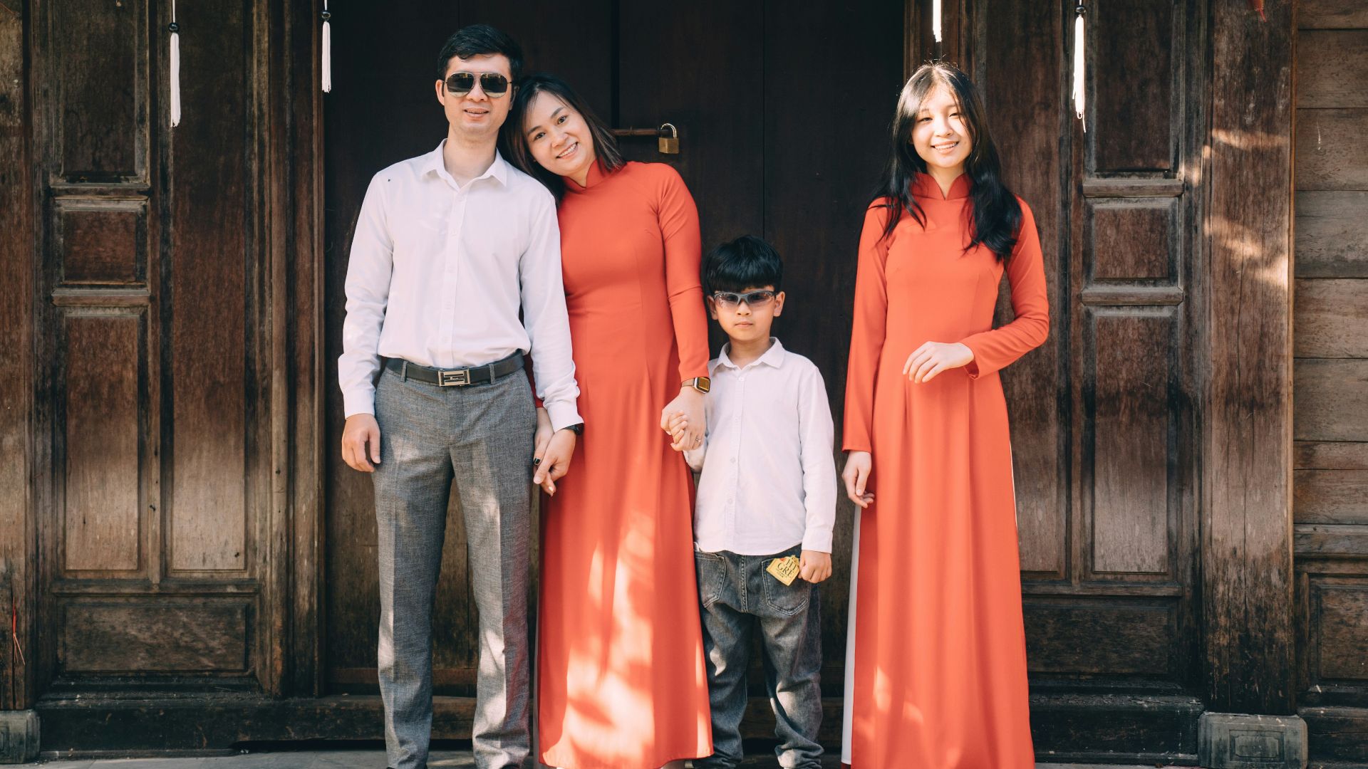 a group of people posing for a photo in front of a wood door