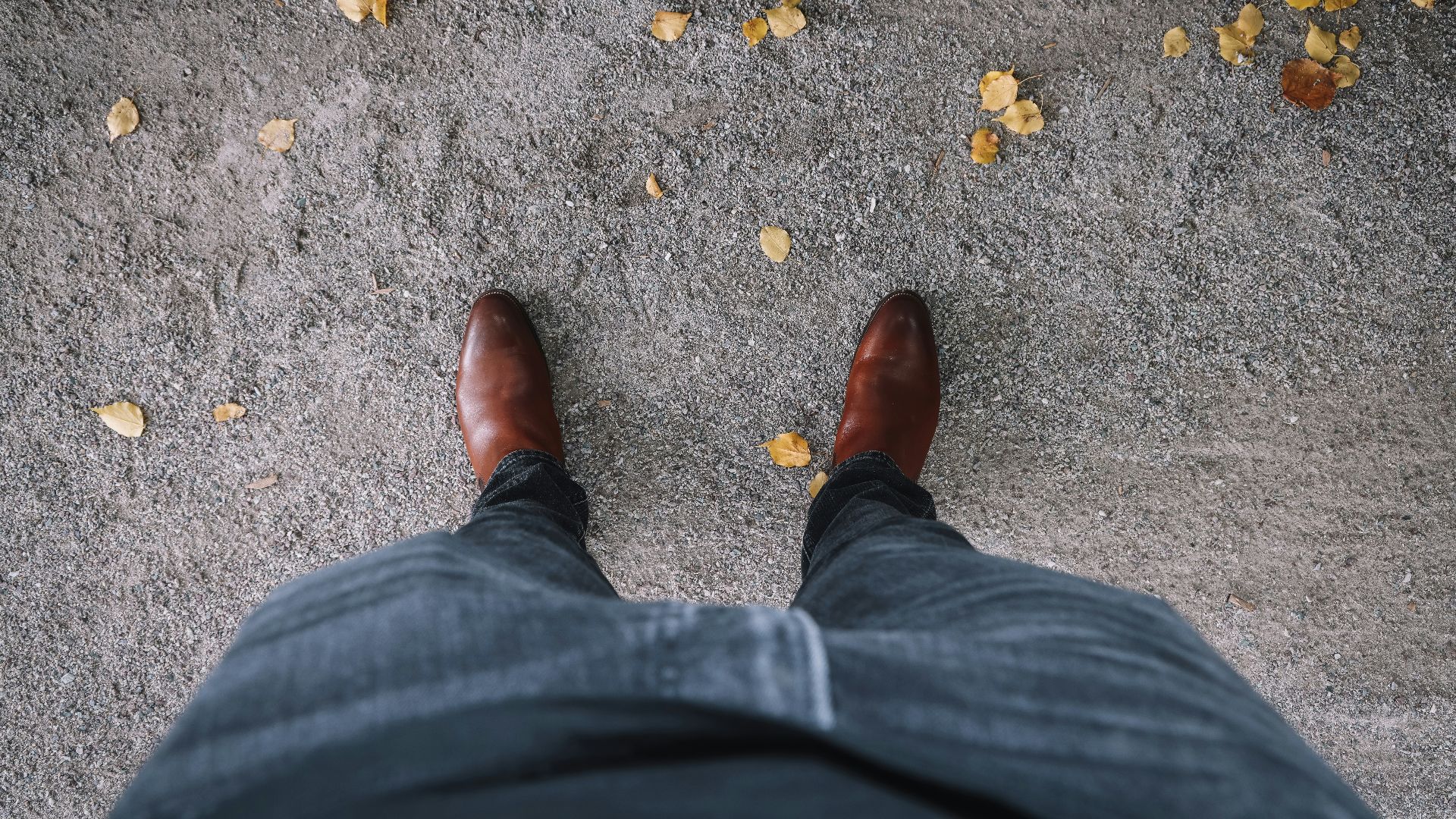 person in black denim jeans and brown leather shoes