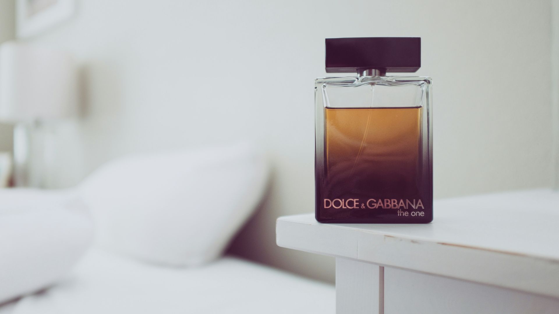 Dolce & Gabbana The One fragrance bottle on white wooden table