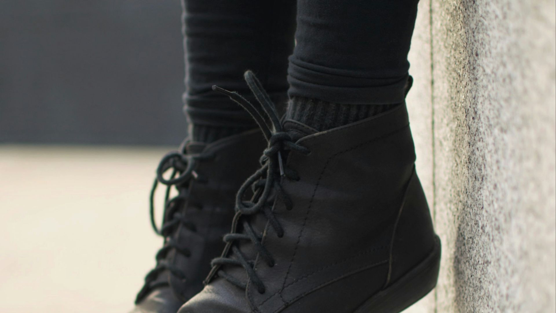 person wearing black lace-up boots