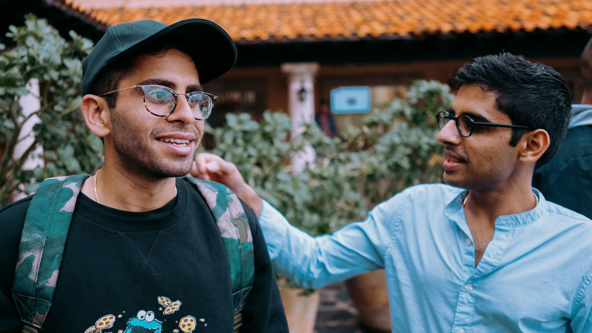 man in black crew neck shirt wearing black framed eyeglasses and black hat