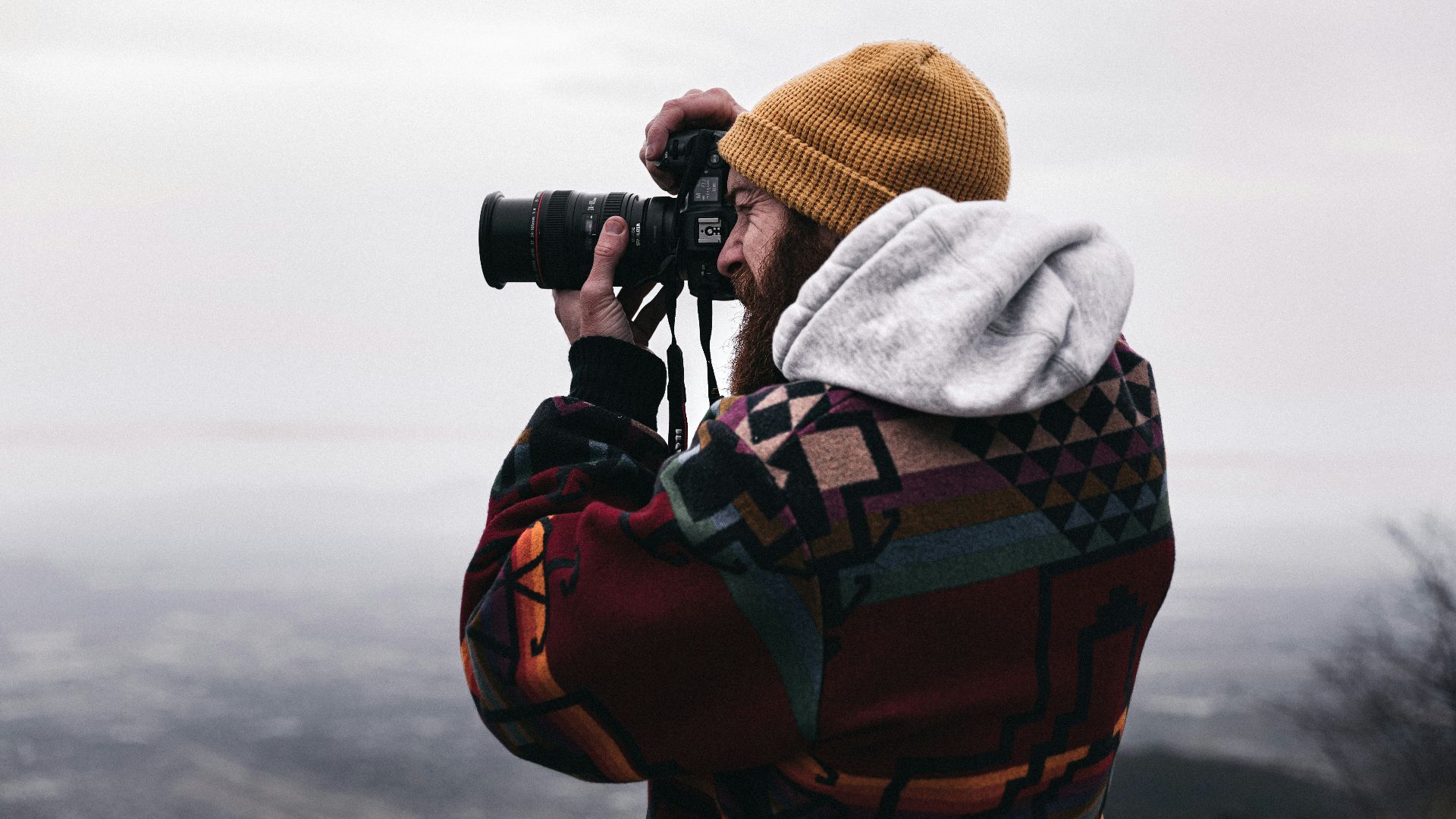person in gray hoodie using black binoculars