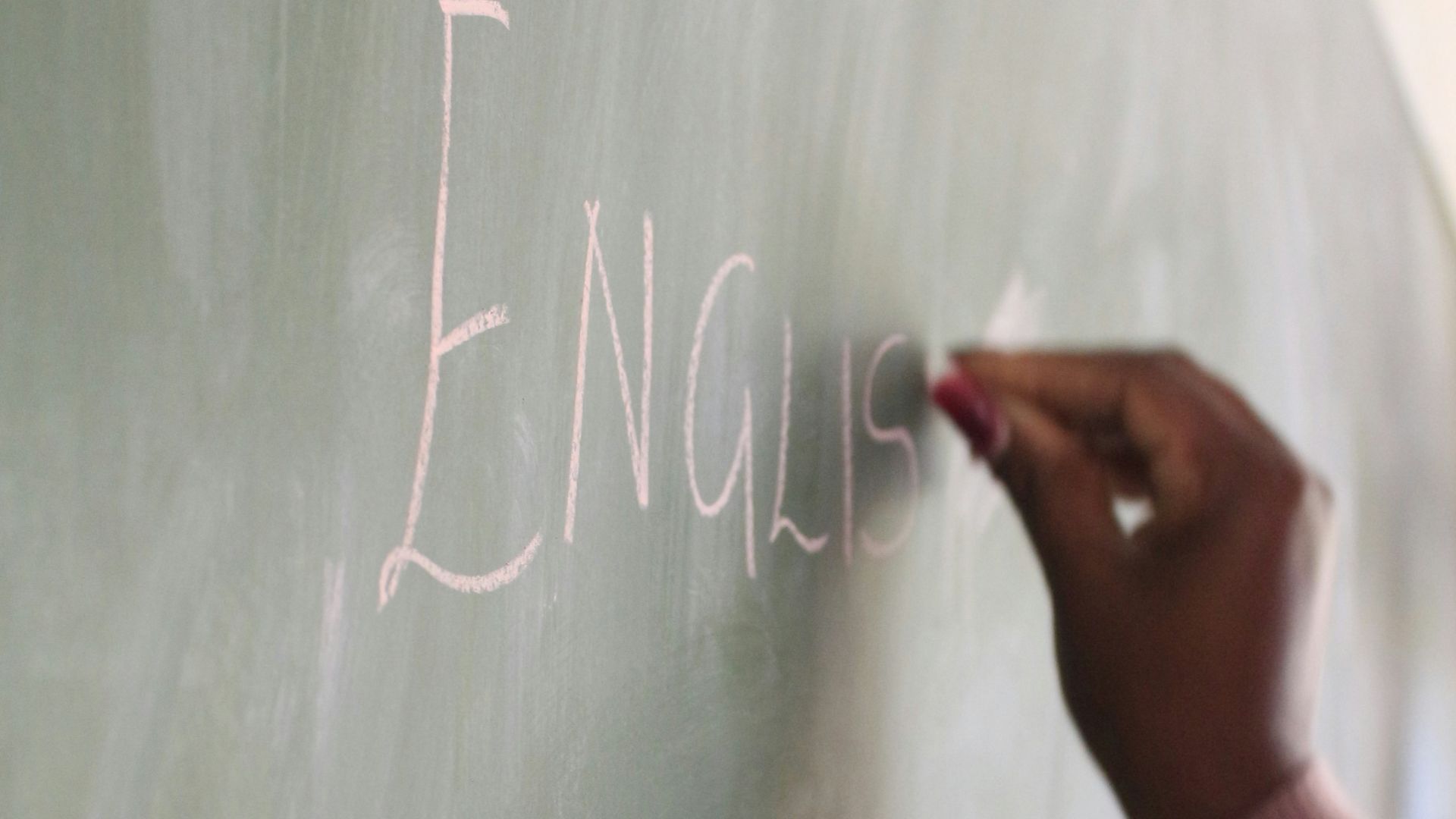 a hand writing on a chalkboard