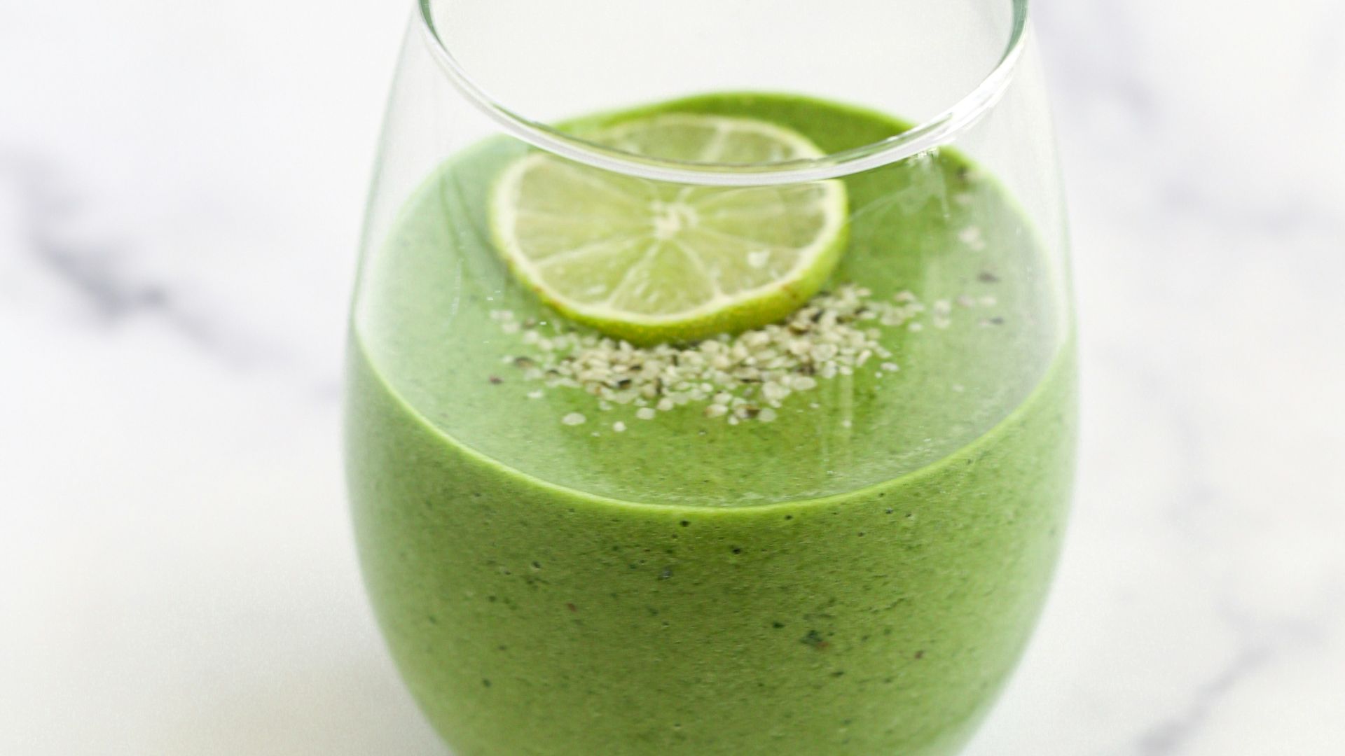 a green smoothie with a lime slice on top