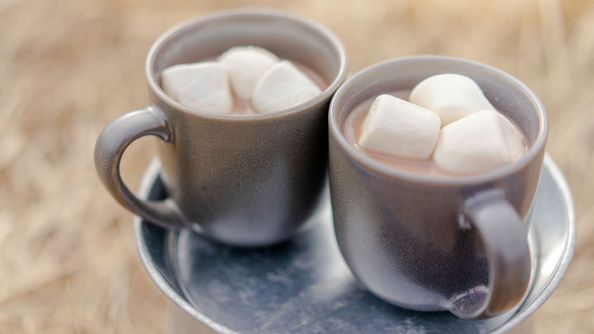 two mugs of beverages and marshmallows