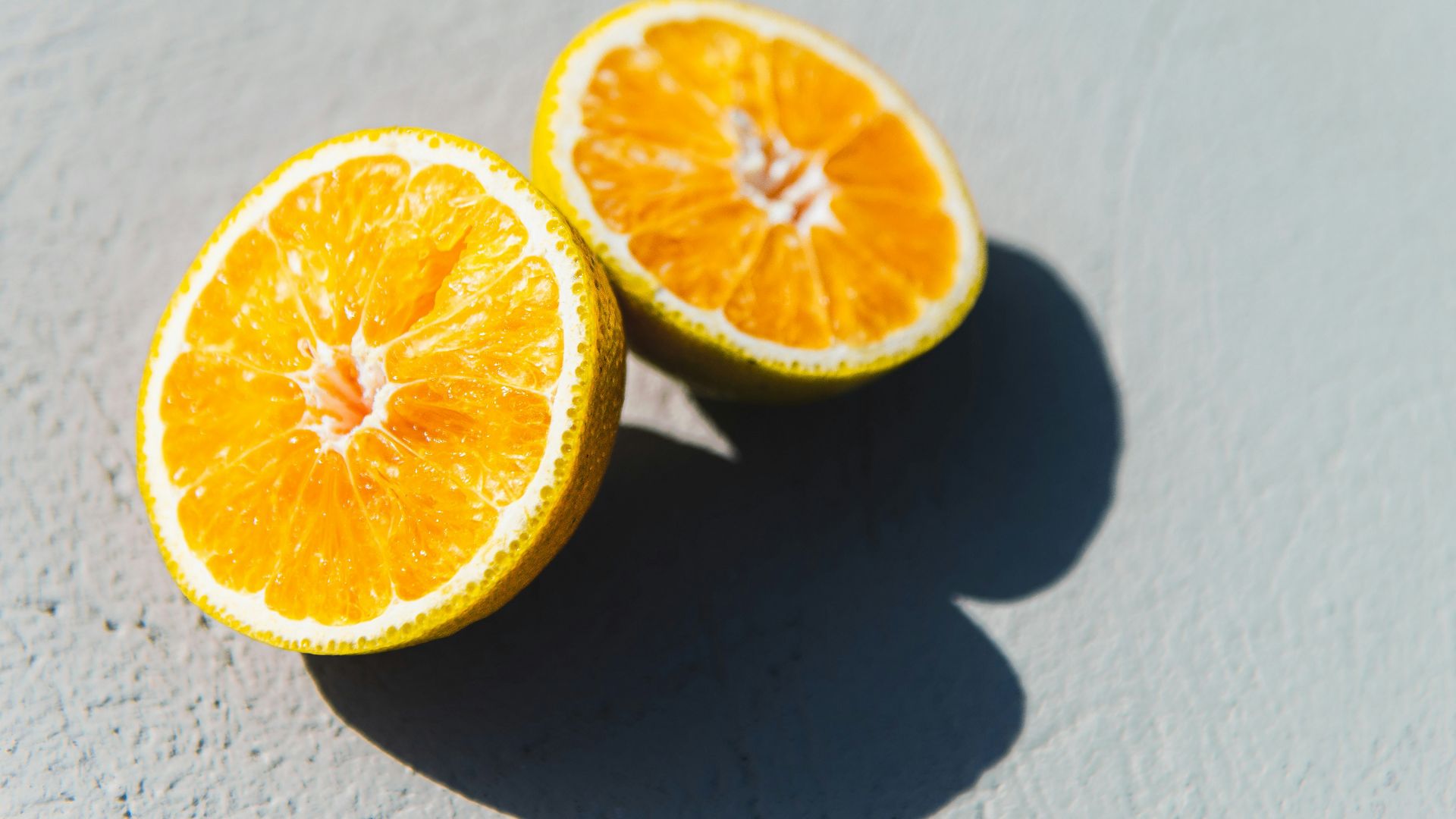 two oranges cut in half sitting on a table