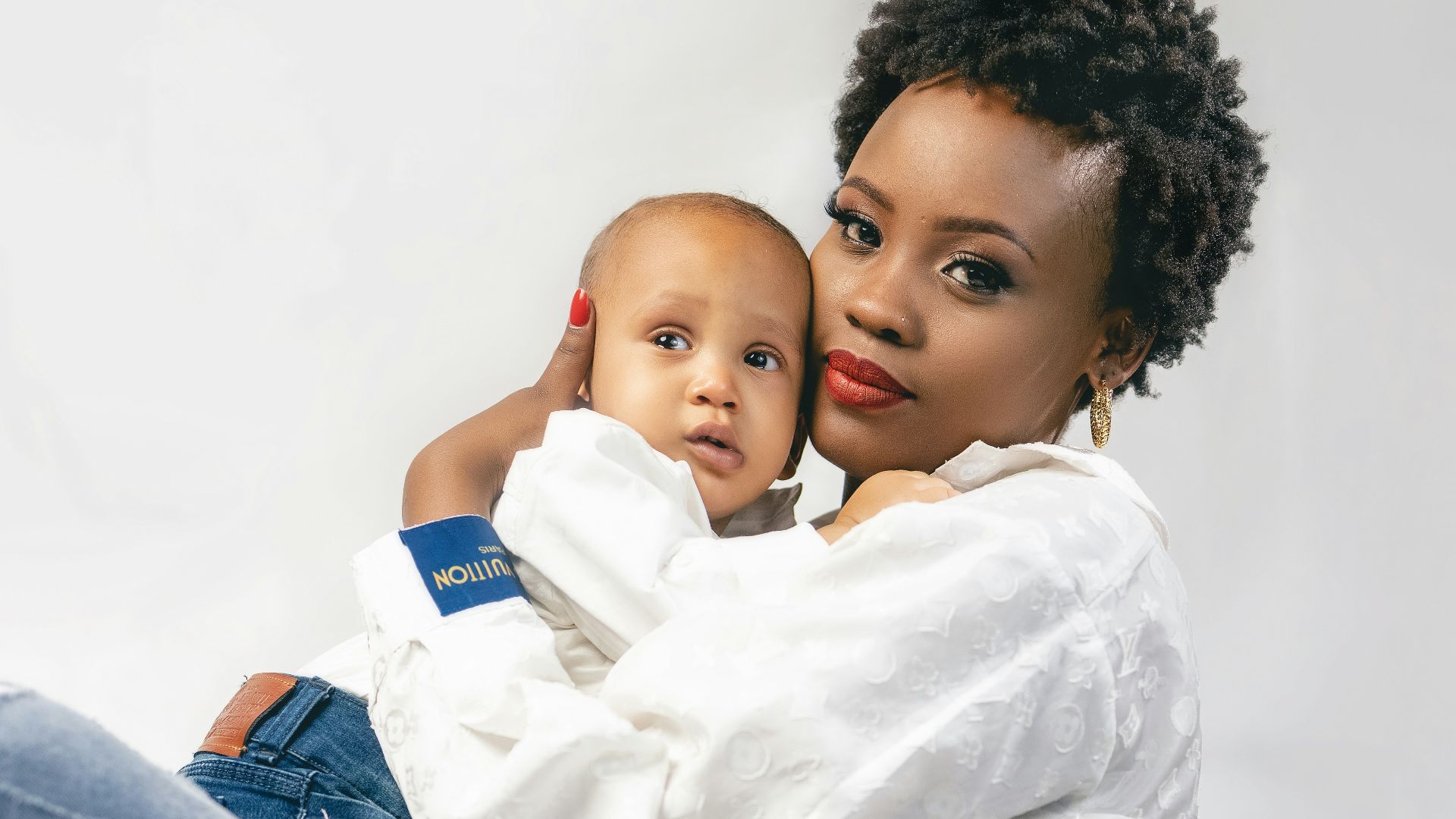 a woman sitting on the ground holding a baby