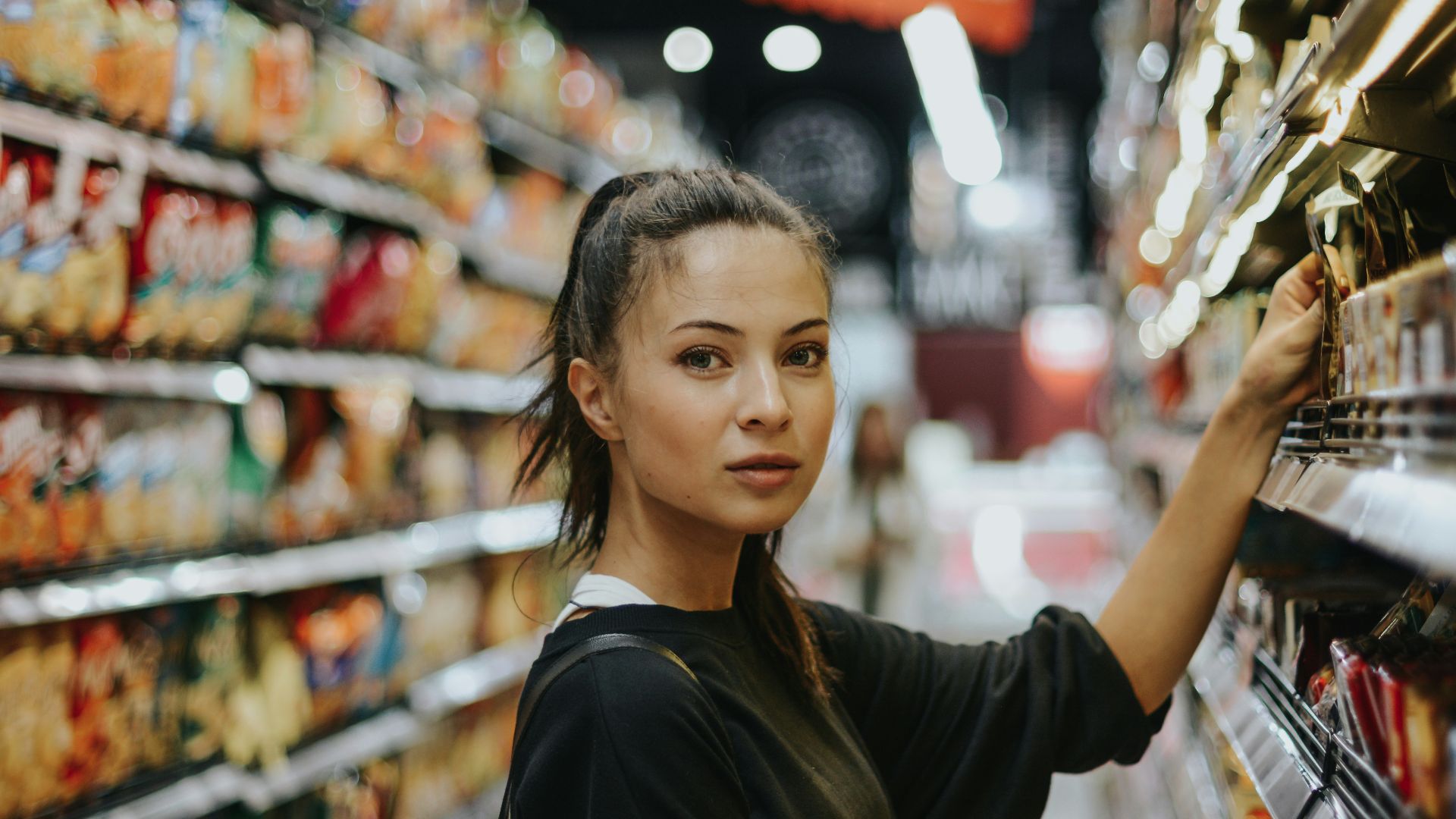 woman selecting packed food on gondola