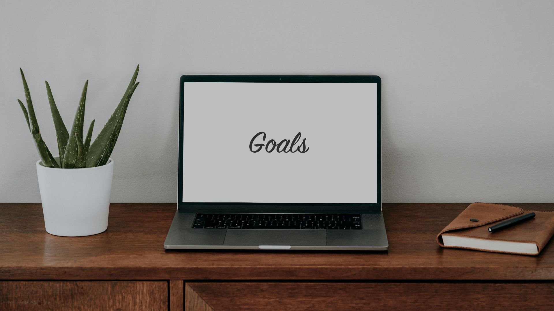 a laptop computer sitting on top of a wooden desk
