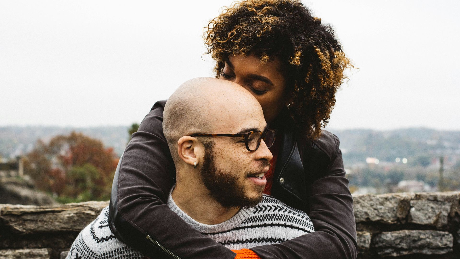 woman kissing man's head