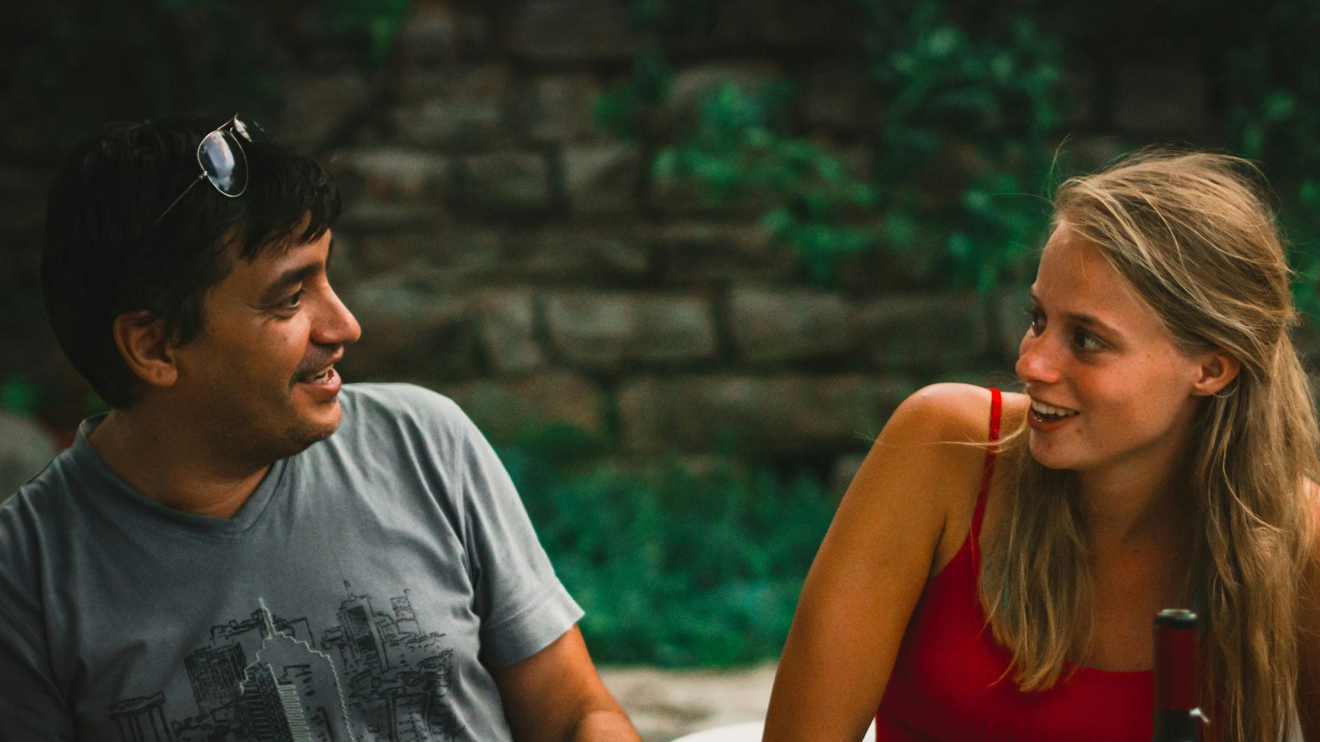 a man and a woman sitting at a table with wine glasses