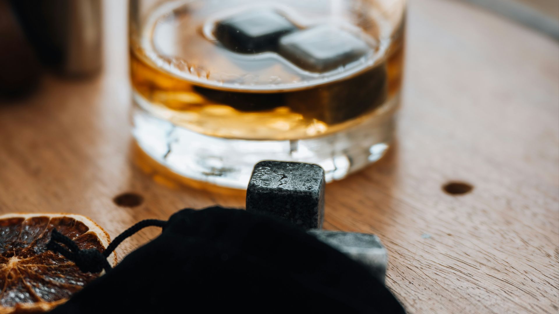 a glass of whiskey sitting on top of a wooden table