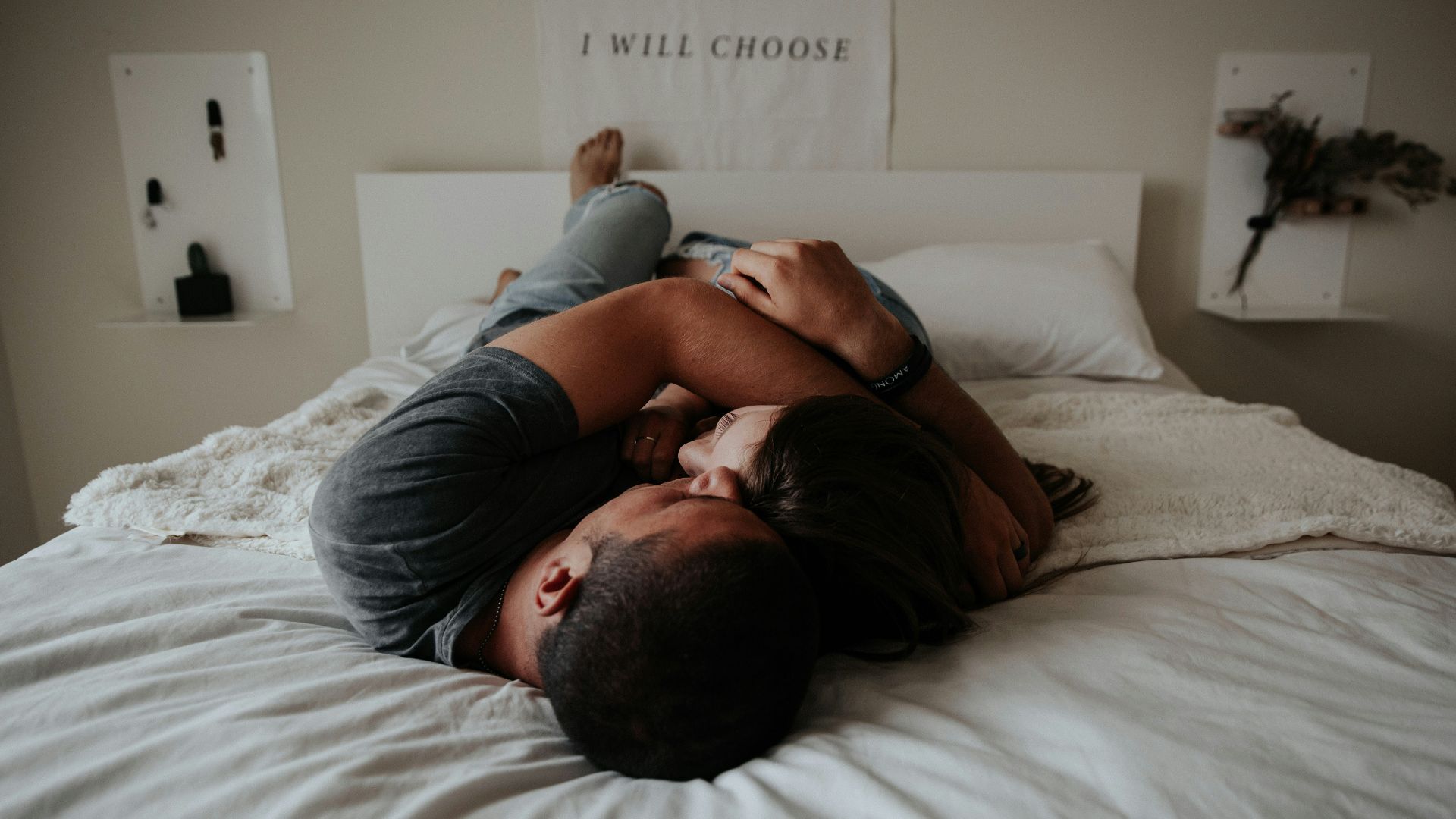 A man and woman cuddling together in bed.