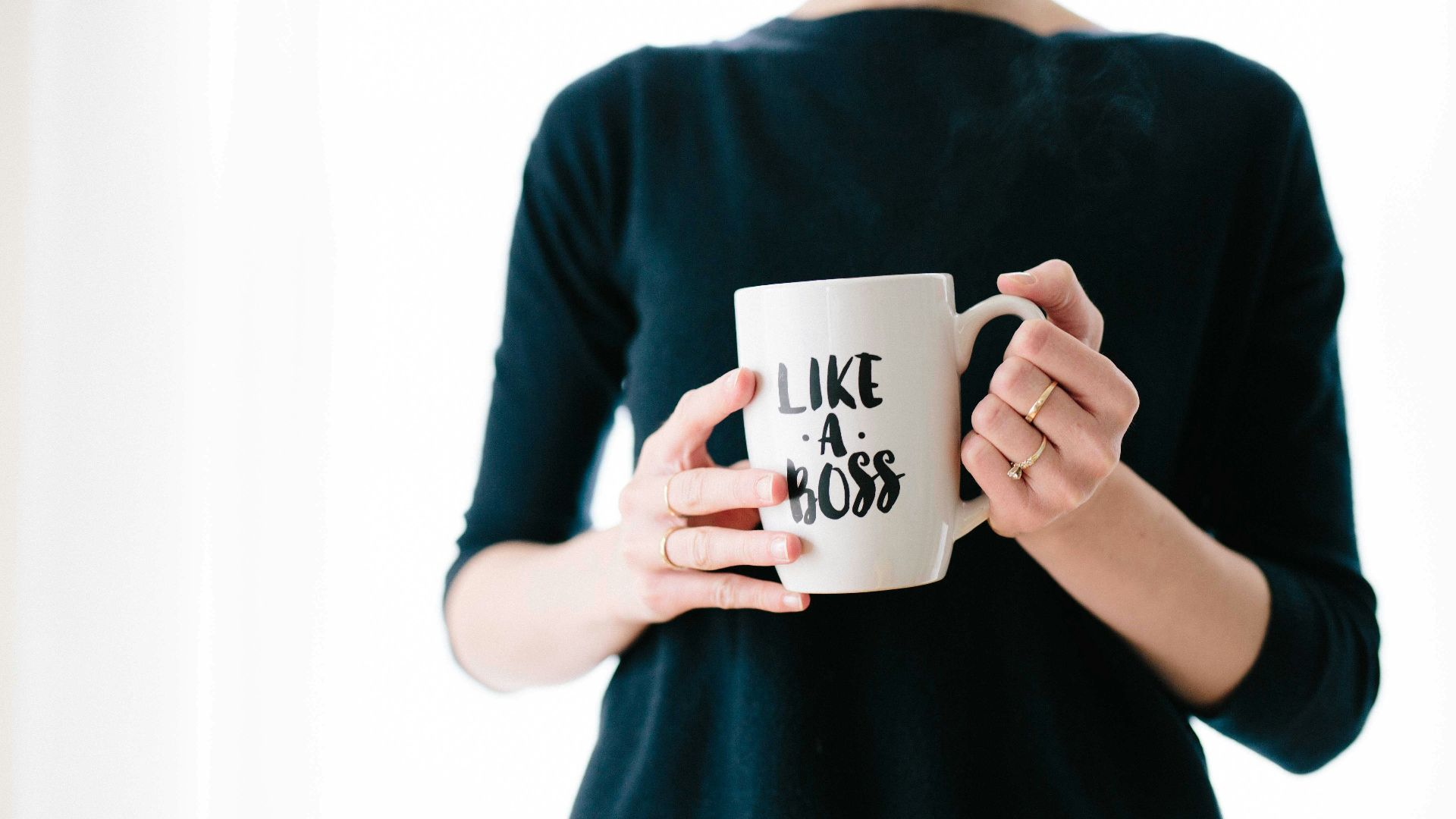 woman holding white mug while standing