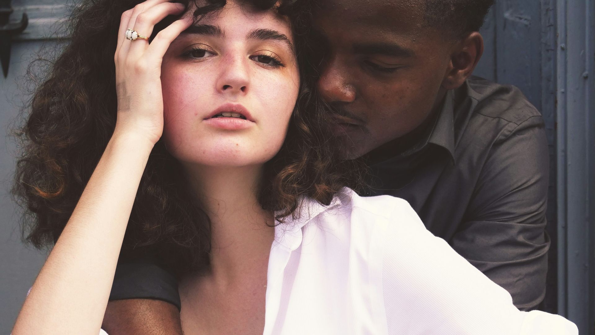 man hugging woman while taking photo of each other