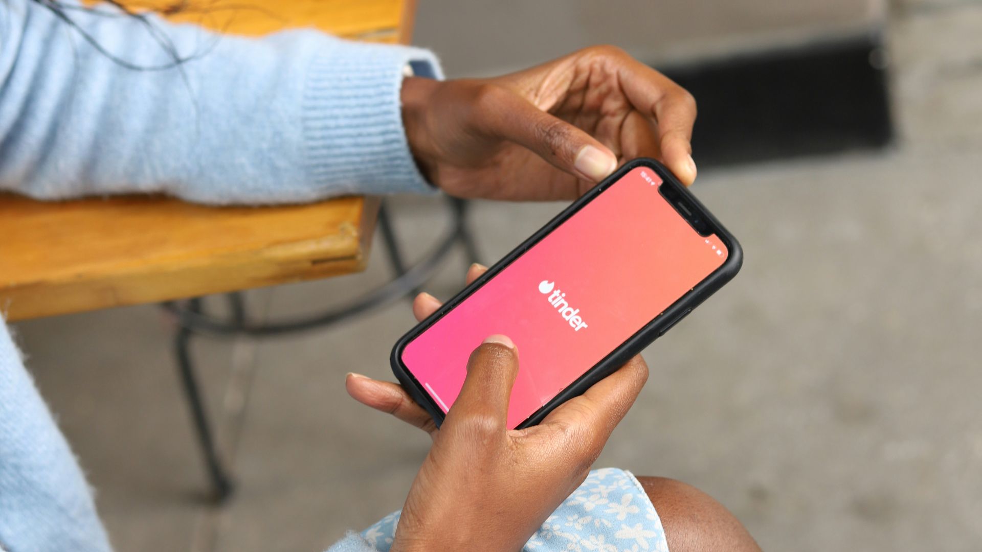 a woman sitting on a bench holding a cell phone