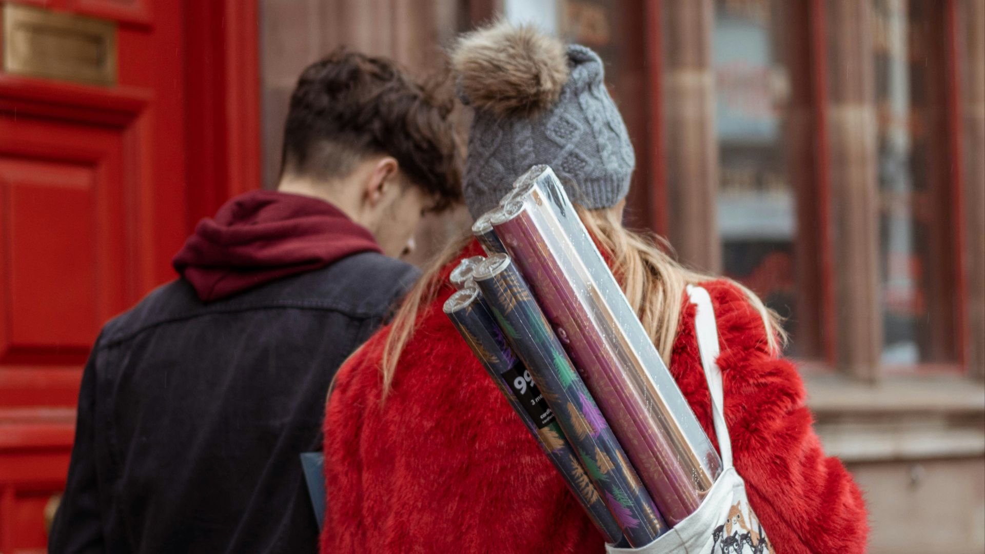woman in red coat holding book