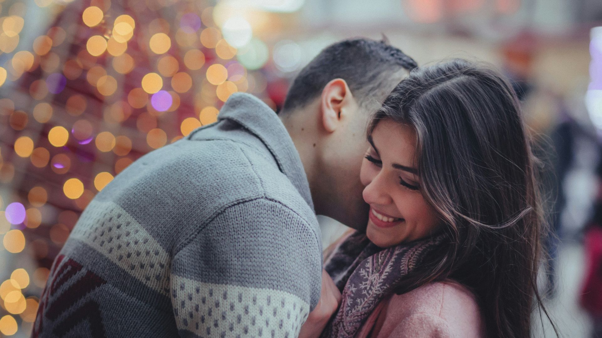 shallow photography of man hugging woman outdoors