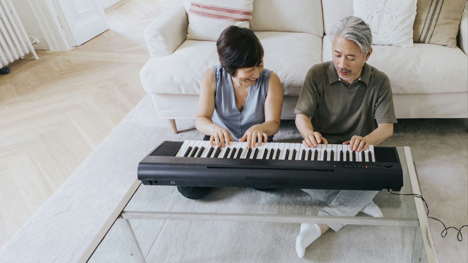 a man and a woman playing a piano on a couch