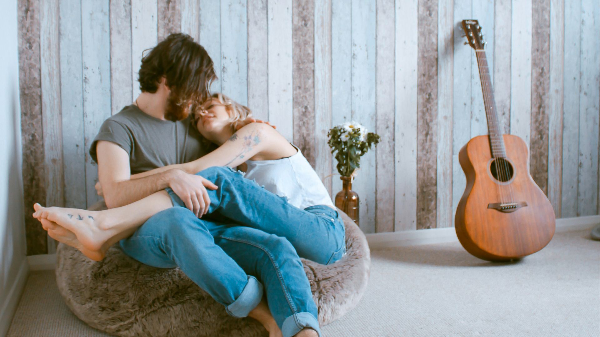 man and woman sitting on gray beanbag