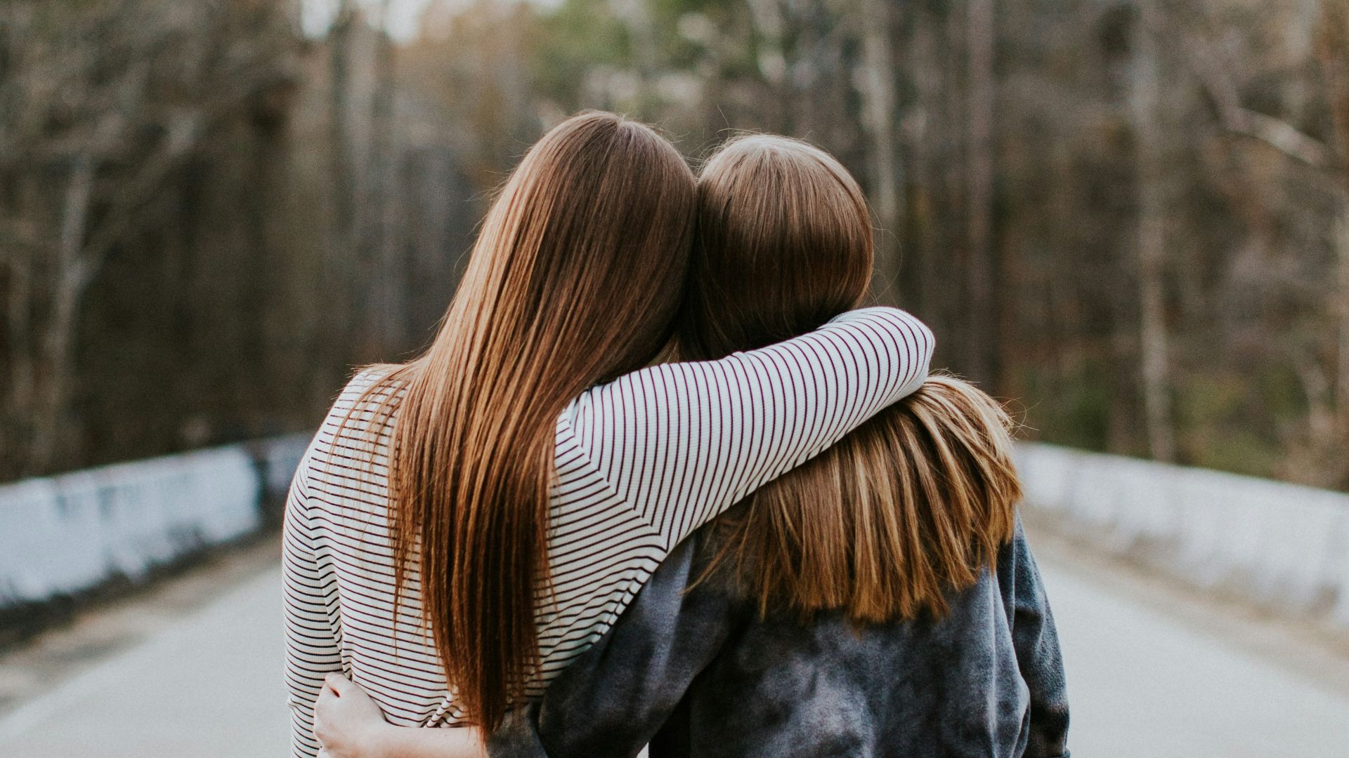 woman in black jacket standing on road during daytime