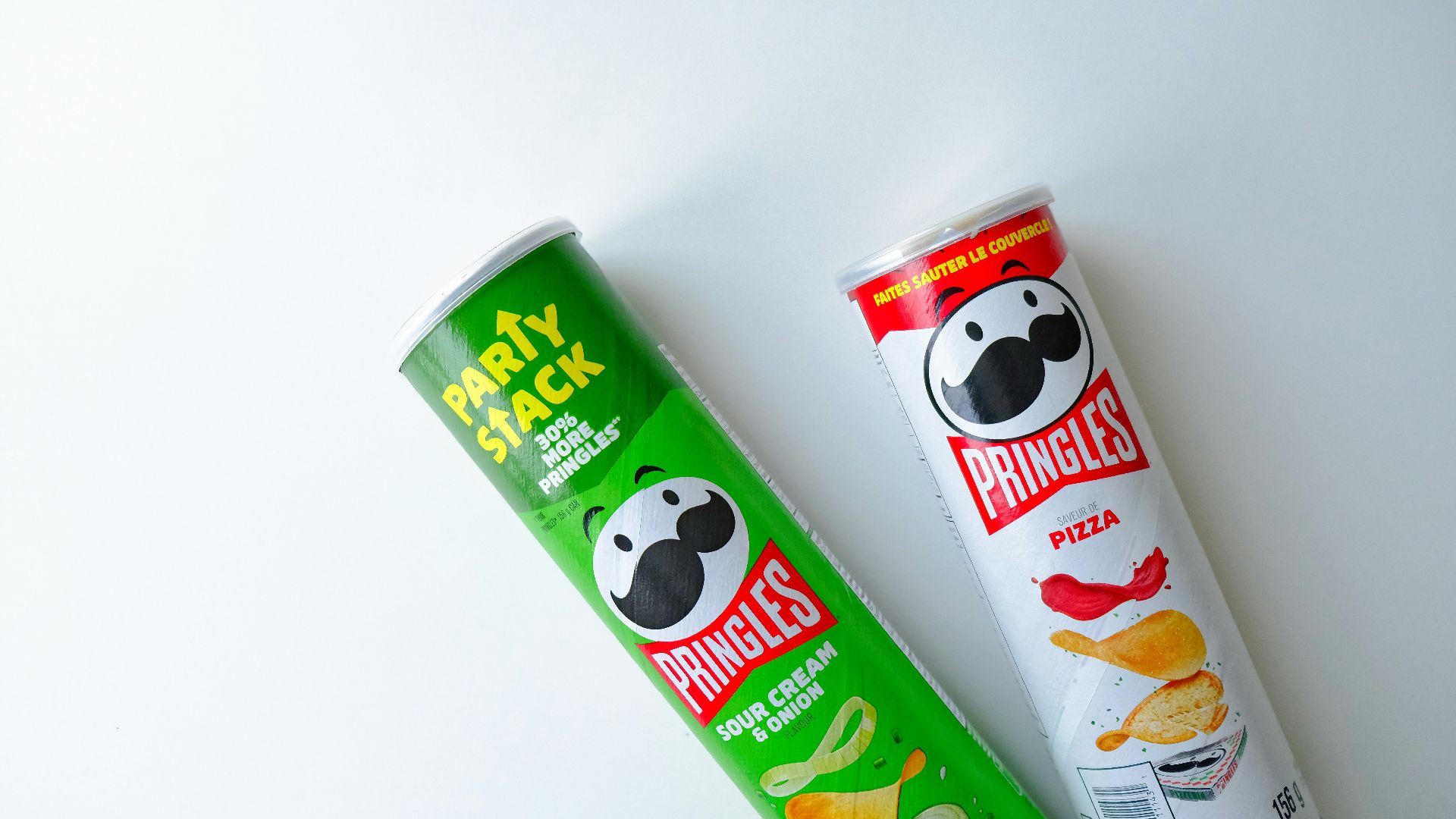 a tube of pringles next to a tube of chips