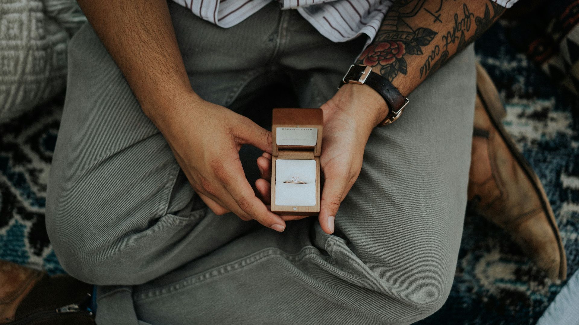 person holding opened brown ring box