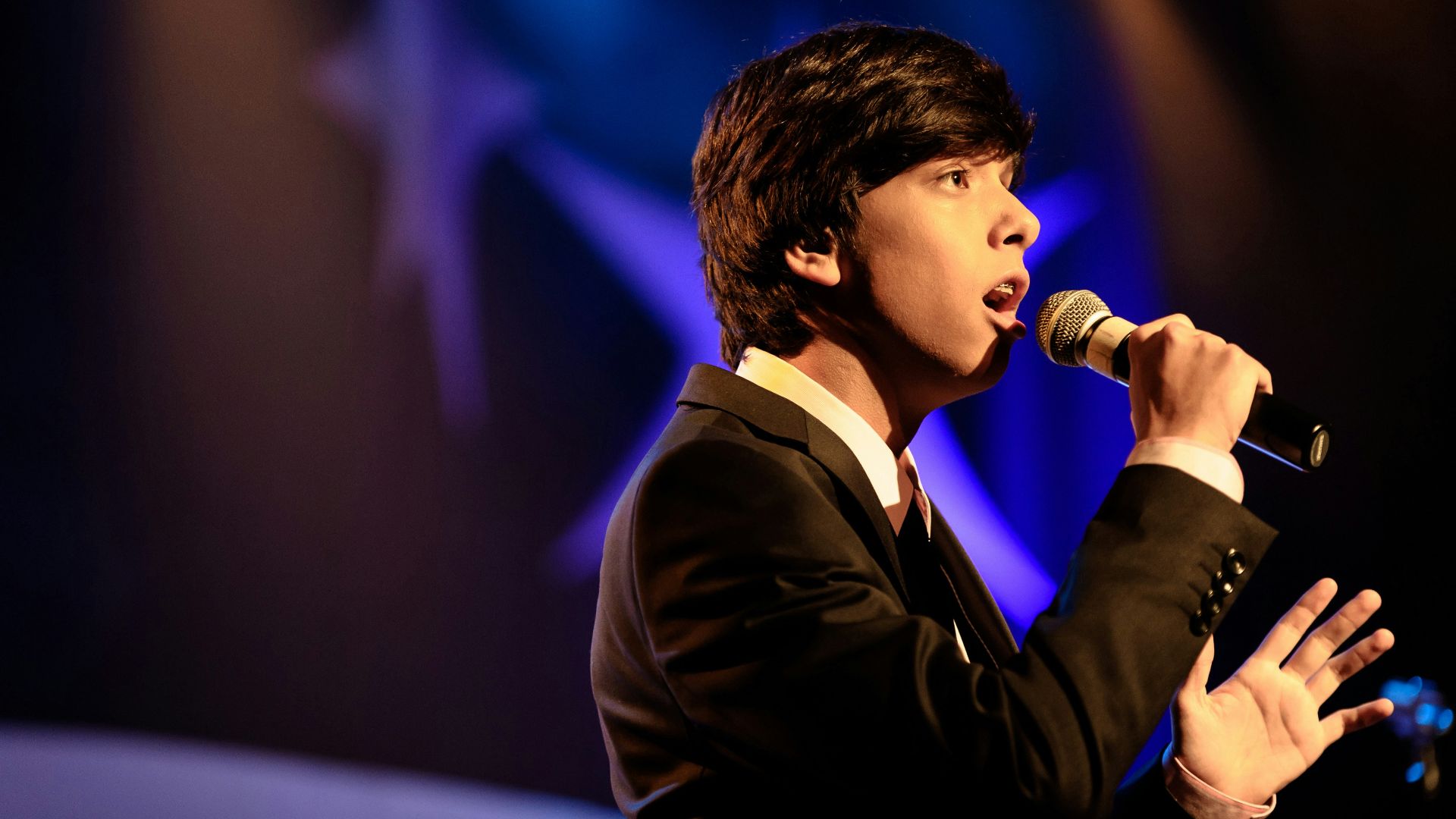 man in black suit singing