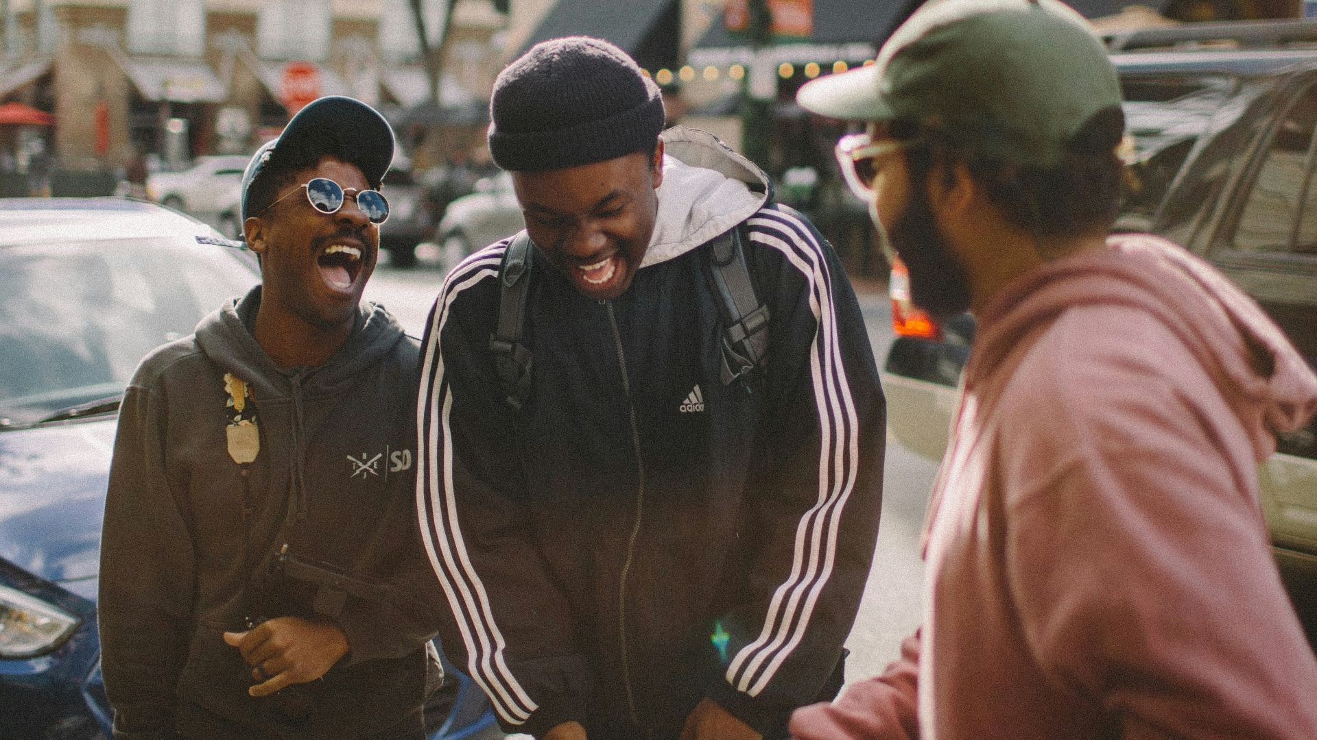three men in jacket laughing at each other