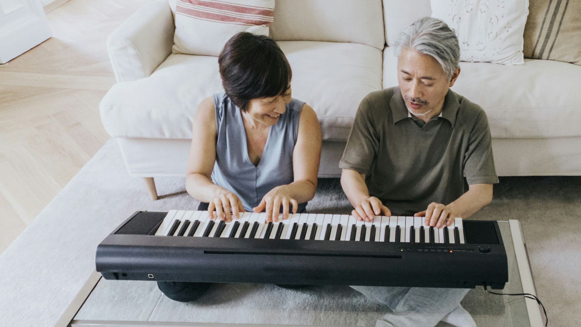 a man and a woman playing a piano on a couch