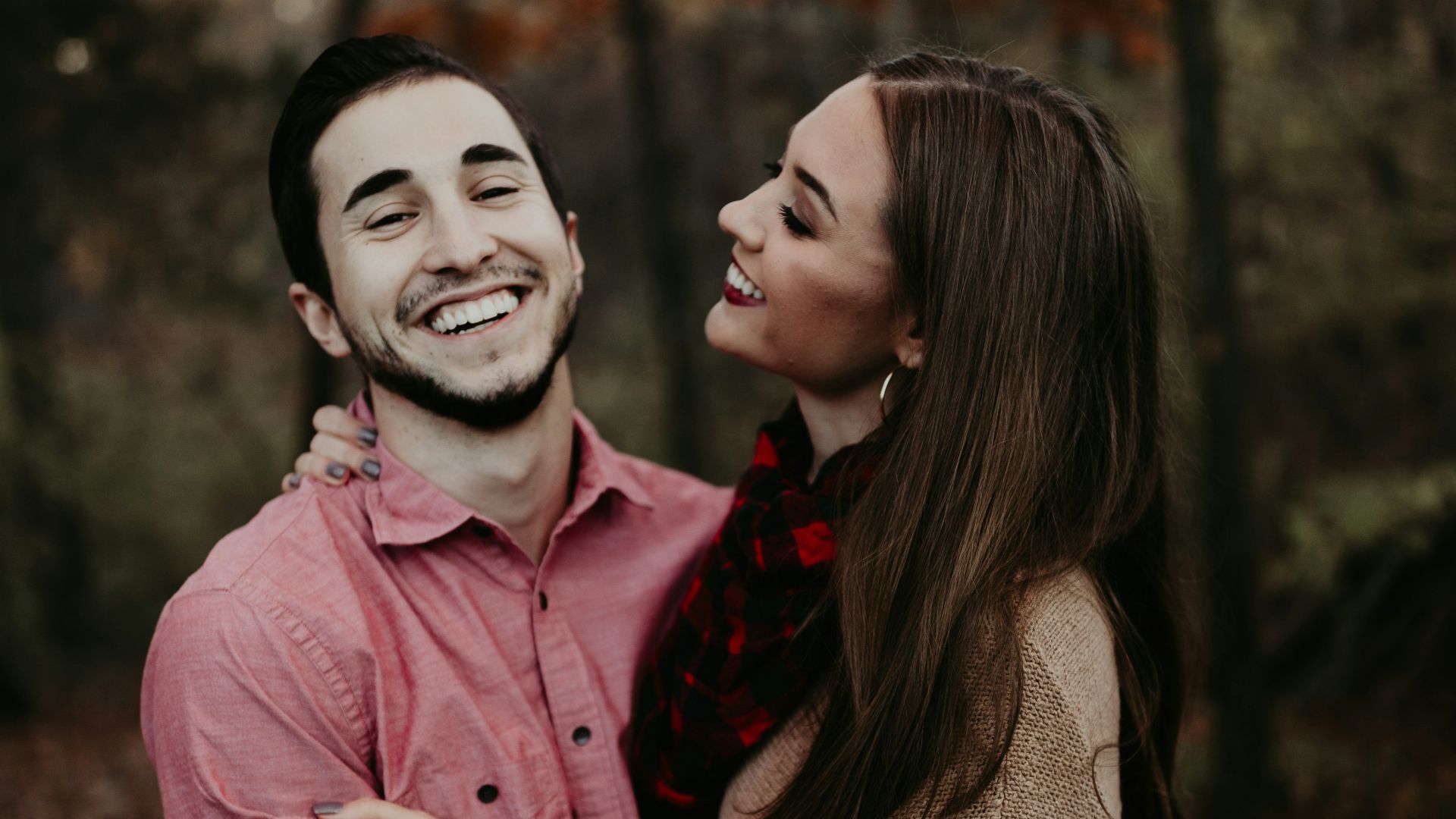 woman hugging man selective focus photography