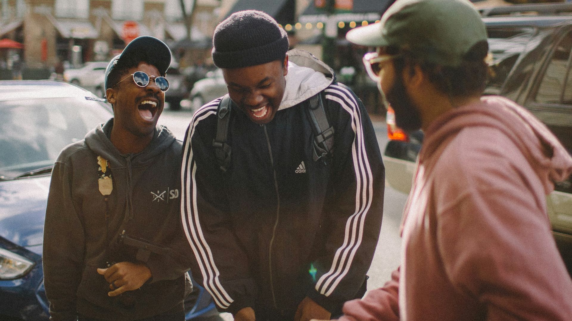 three men in jacket laughing at each other