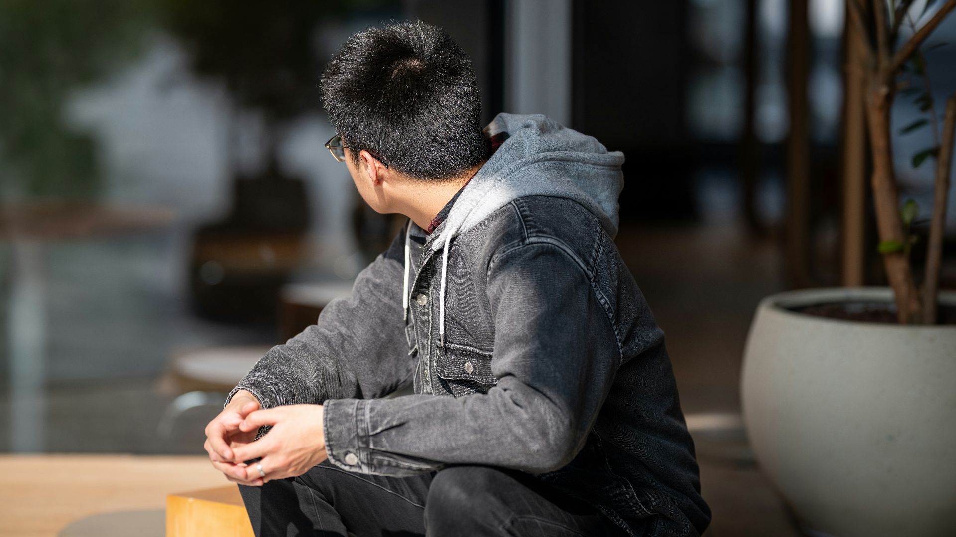a man sitting on a table with his hands in his pockets