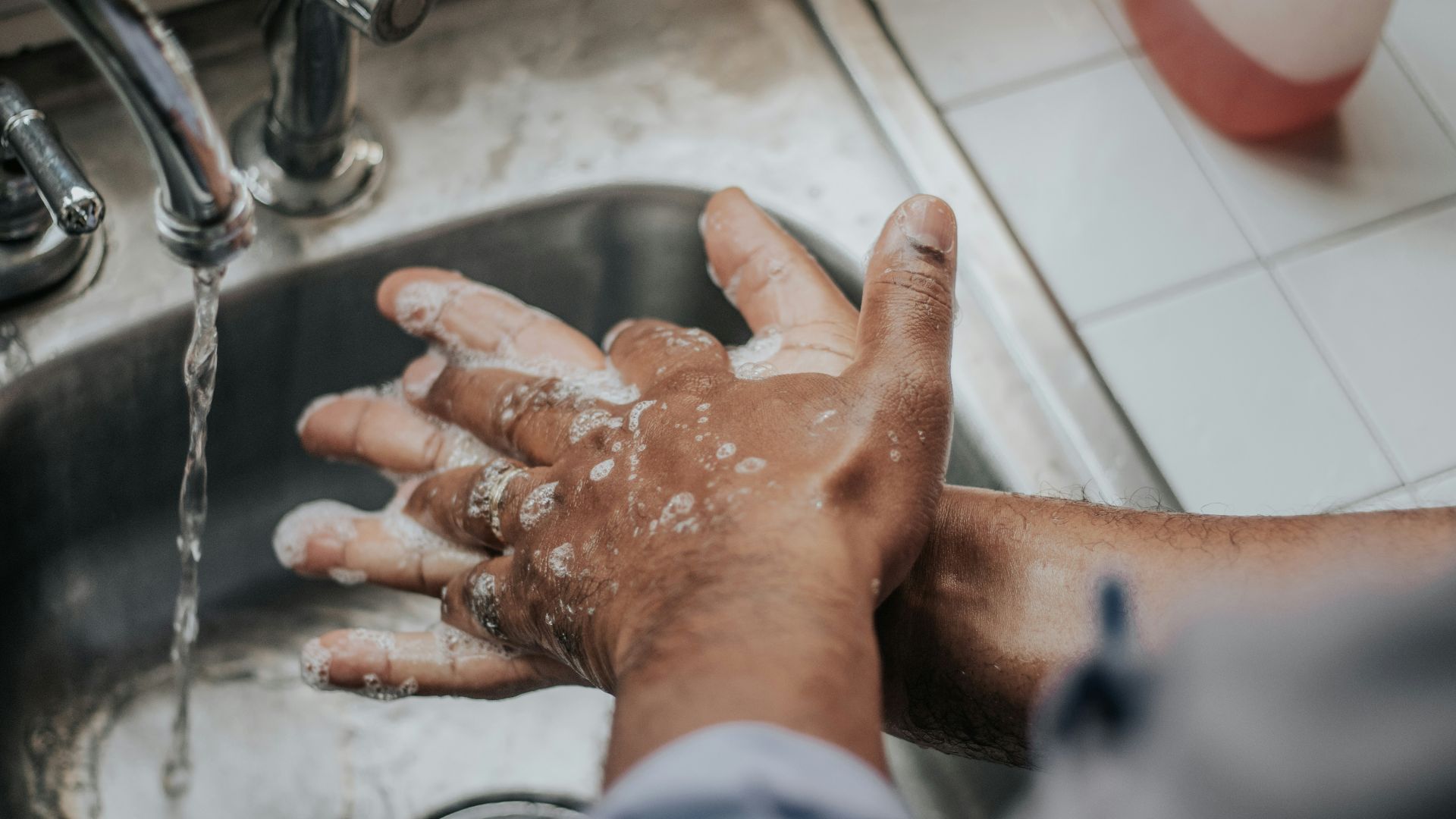 person in white shirt washing hands