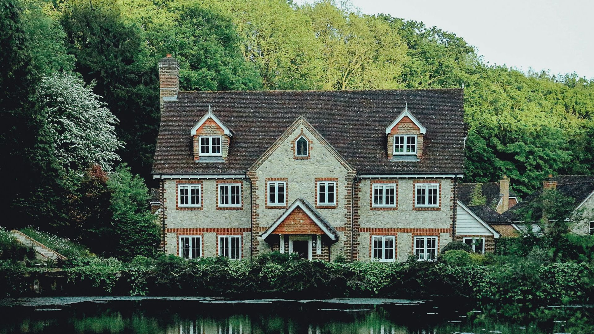concrete house near a body of water and forest